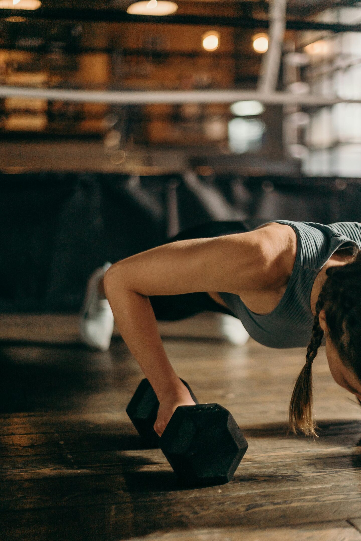 Woman in Black and White Tank Top and Black Shorts Lying on Brown Wooden Floor
